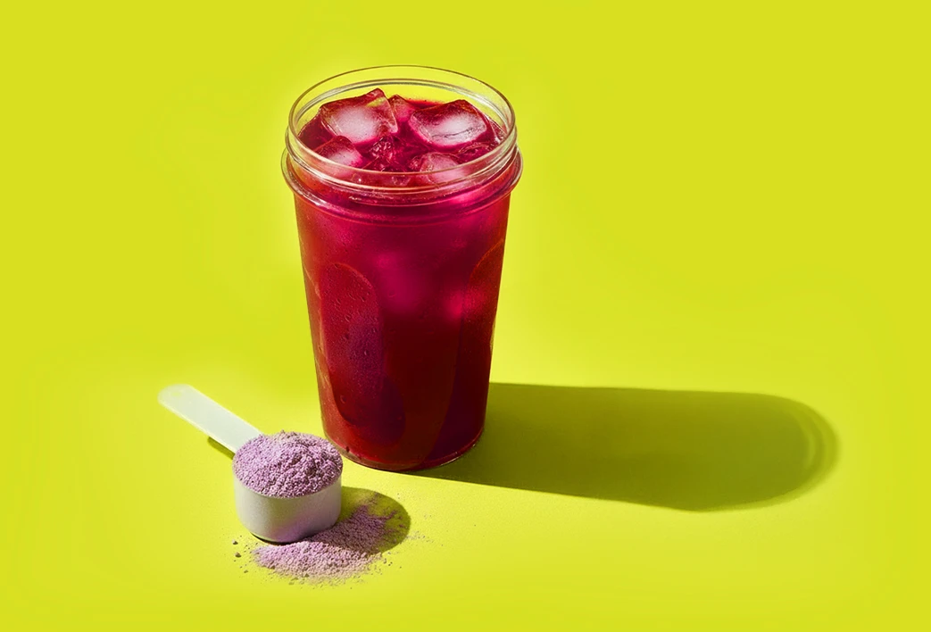 Copo cheio com biO2 Energy Shot e um scoop ao lado