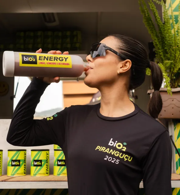 Mulher bebendo garrafa de biO2 Energy Shot