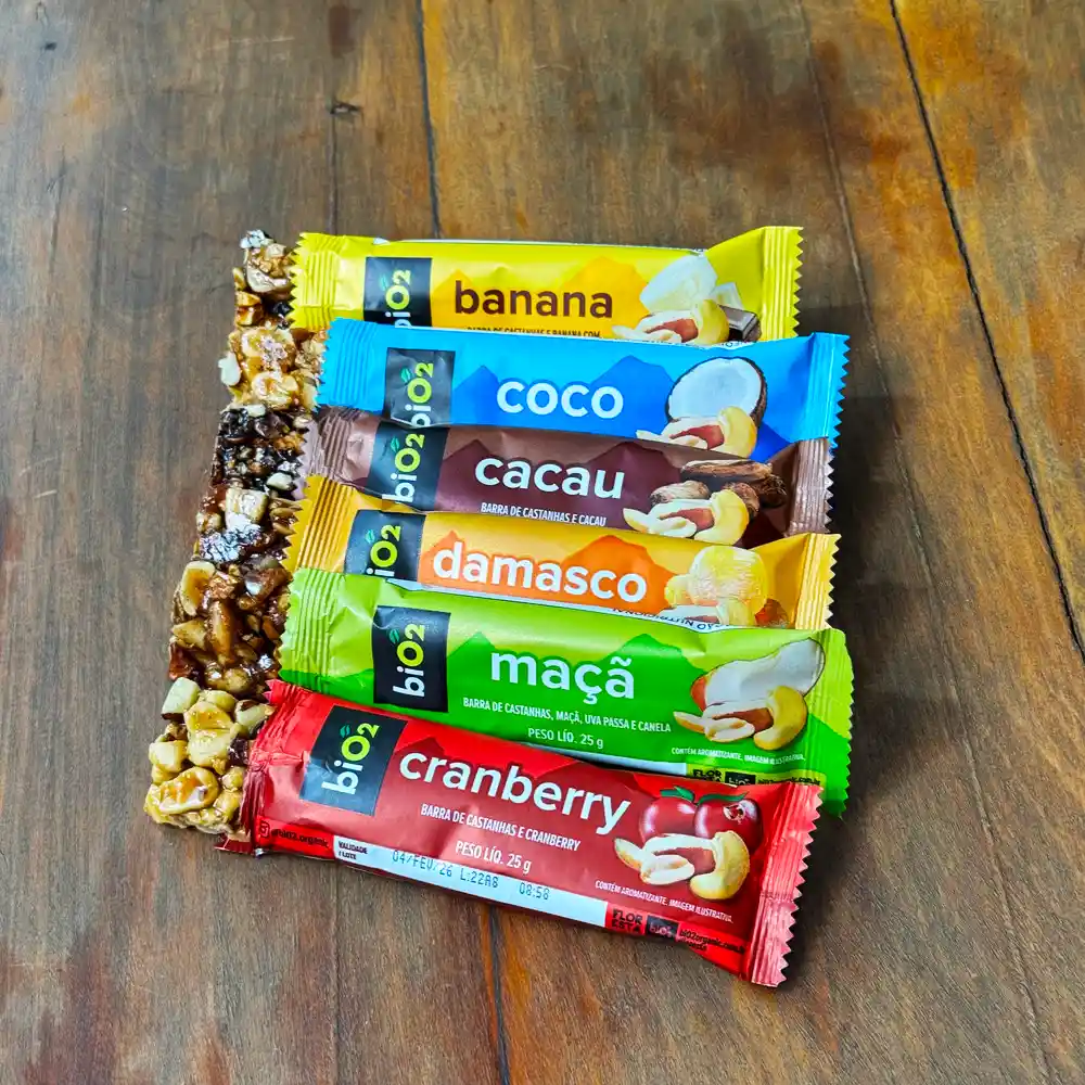 Seis barras de castanhas veganas biO2 em diferentes sabores: banana, coco, cacau, damasco, maçã e cranberry, com 25g cada.