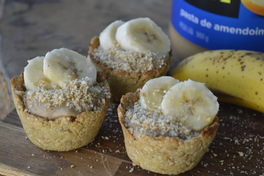 Receita de mini tortinha doce vegana e sem glúten à base de grão de bico, quinoa e linhaça. Com recheio cremoso e proteico feito com pasta de amendoim.