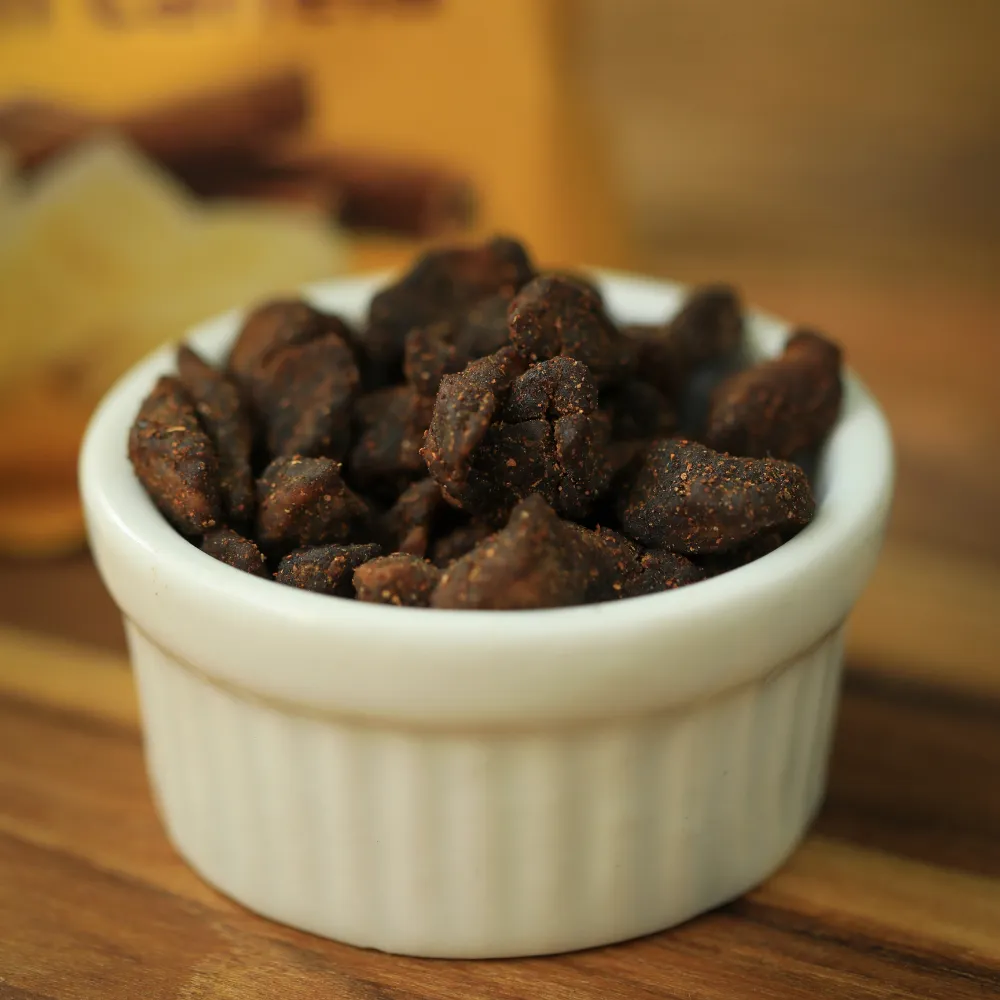 Bananas desidratadas em cubos com canela biO2, vegano e sem glúten, em um pote de cerâmica