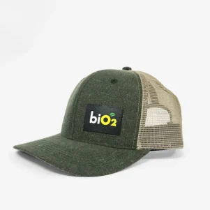 Boné biO2 estilo Trucker, cor verde militar na aba e parte da frente e tela bege na parte do meio para trás, com o logo da marca em quadrado preto no canto inferior direito na parte da frente.